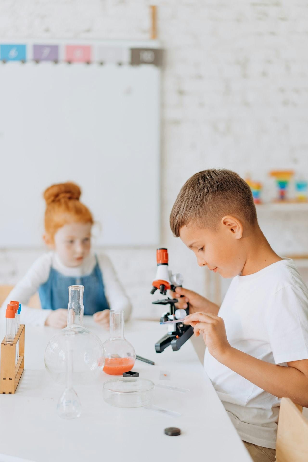 Children with microscope studying science at school