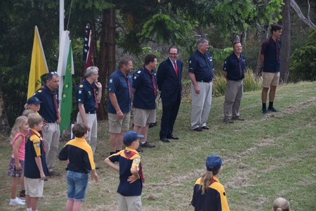 Scouts members on grass in front of scrubs