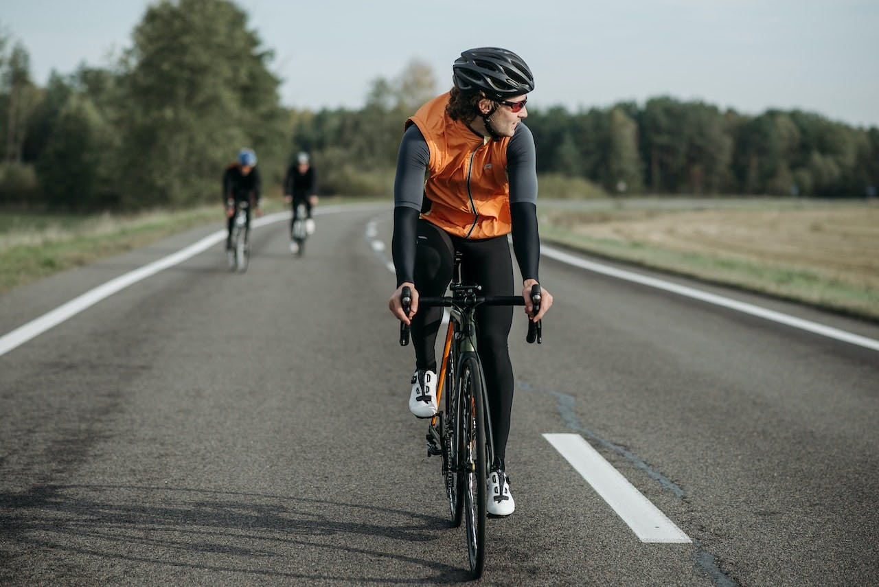 Cyclist on road with 2 cyclists in background