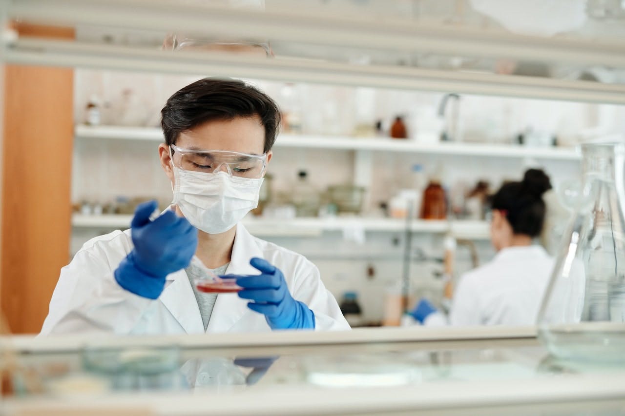 Scientist holding pipette and petri dish