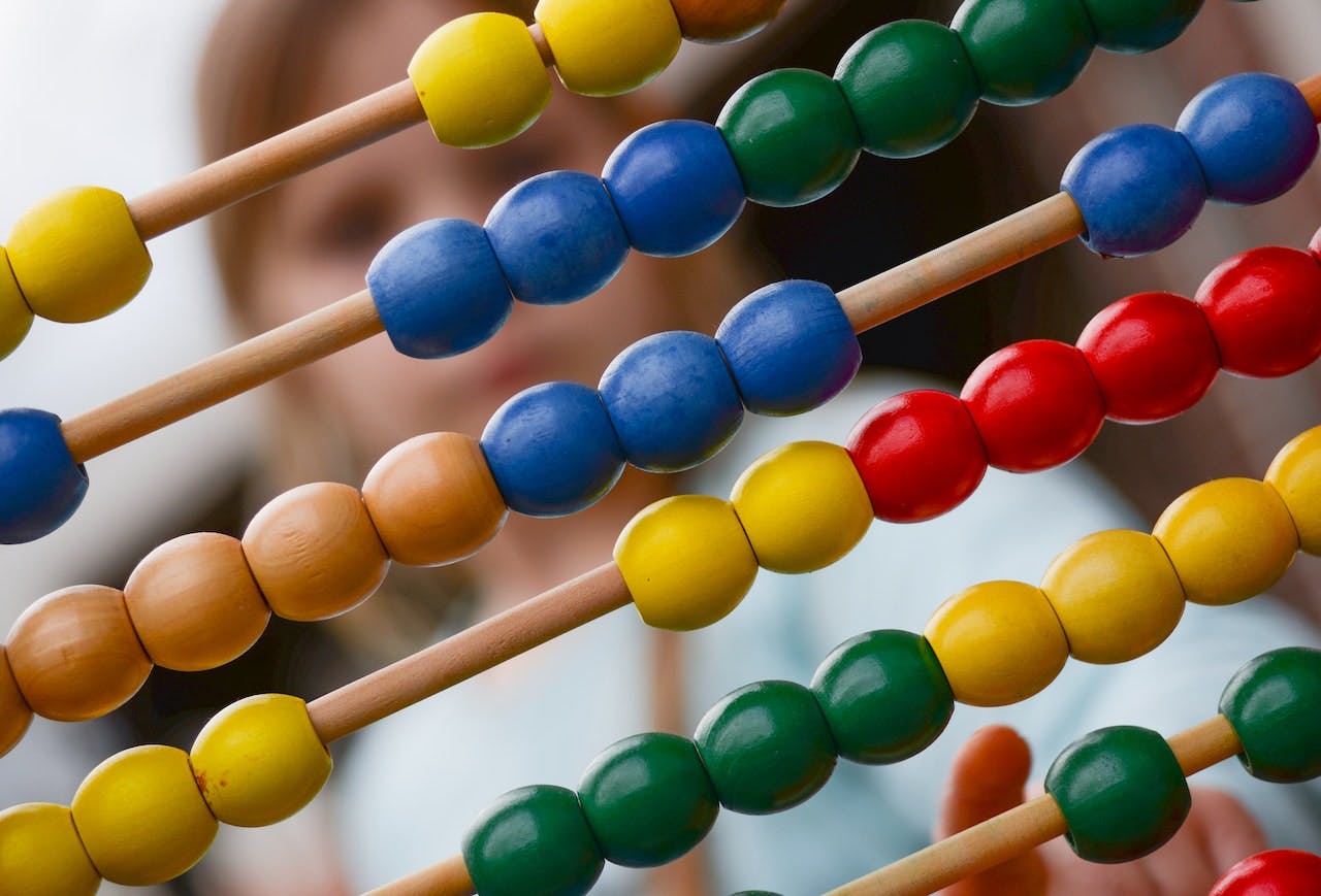 Bright coloured abacus in foreground with child in background